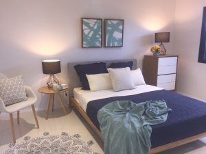 modern bedroom with lamps, blue bed and side chair