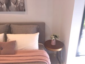 bedroom with side table and ornamental plant on top
